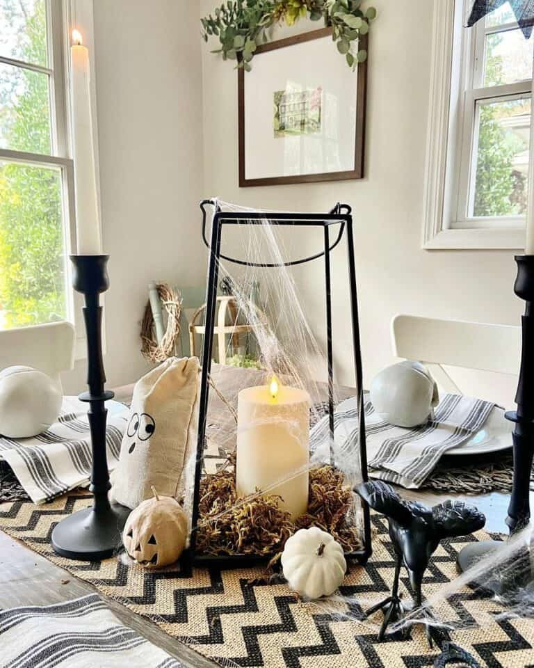 Black lantern with white pumpkins and fall foliage