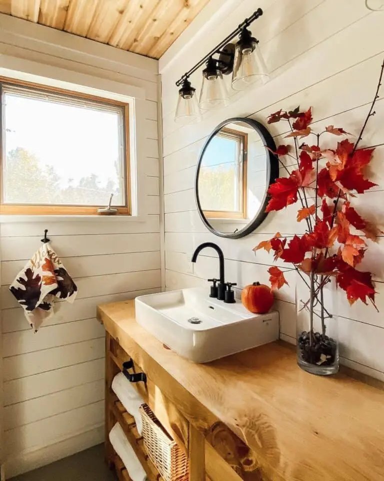 Cream shiplap walls
Red leaf vase
Wood vanity
Leaf print towel