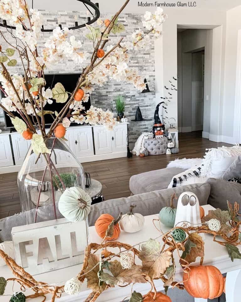 White side table with pumpkins and fall leaves